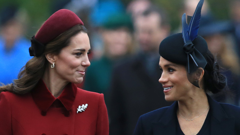 Kate Middleton and Meghan Markle smiling at each other