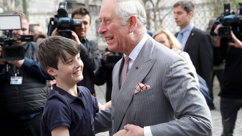 Prince Charles hugging a child