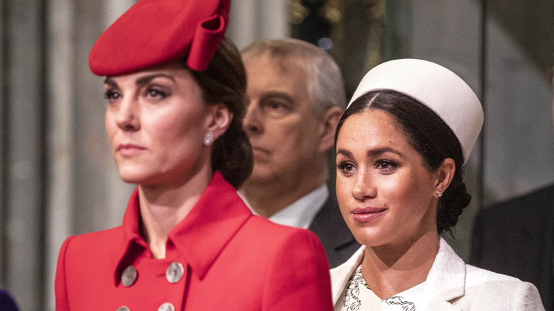 Kate Middleton looking serious, Meghan Markle smirking