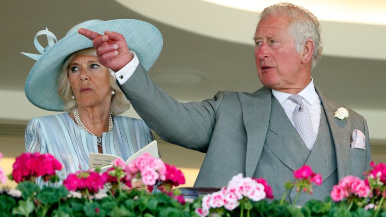 King Charles pointing next to Camilla Parker Bowles