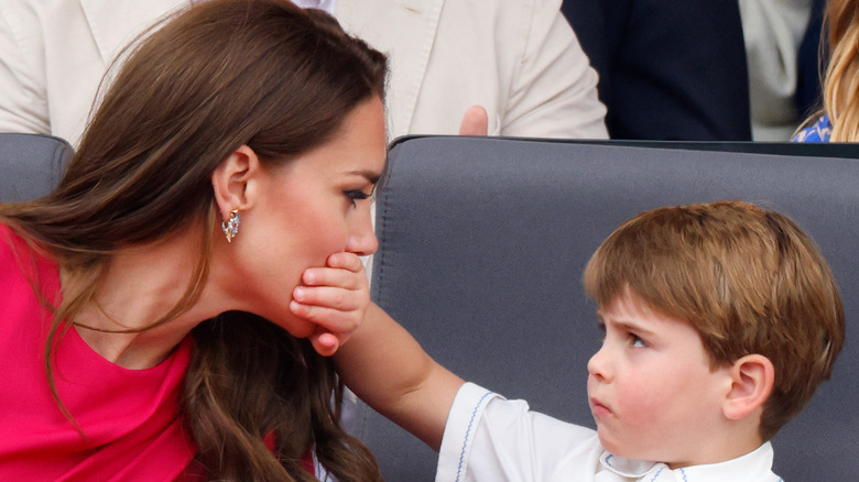 Prince Louis with his hand over Kate Middleton's mouth