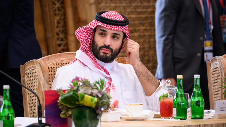 Mohammed bin Salman looking to side, scratching ear