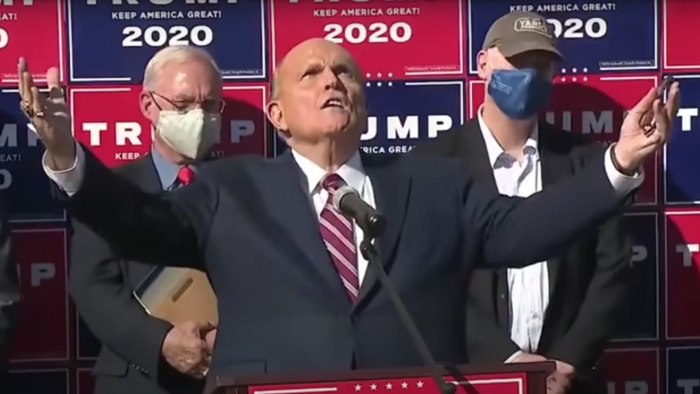 Rudy Giuliani looking to the sky with arms outstretched 