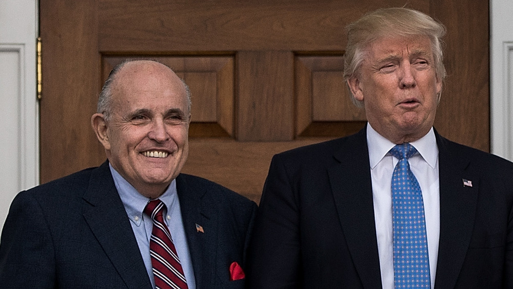 Rudy Giuliani and Donald Trump standing under an arch