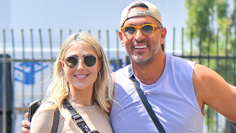 Mauricio Umansky and Emma Slater posing and smiling together, walking into rehearsal