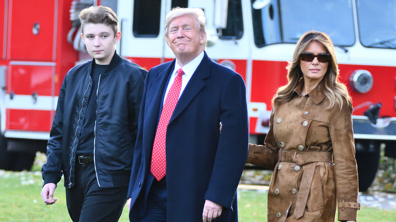 Barron Trump walks with his parents