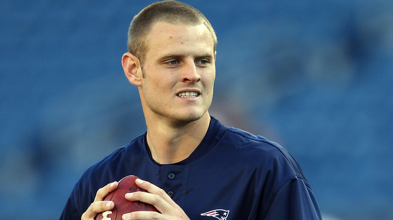 Ryan Mallet, holding a football