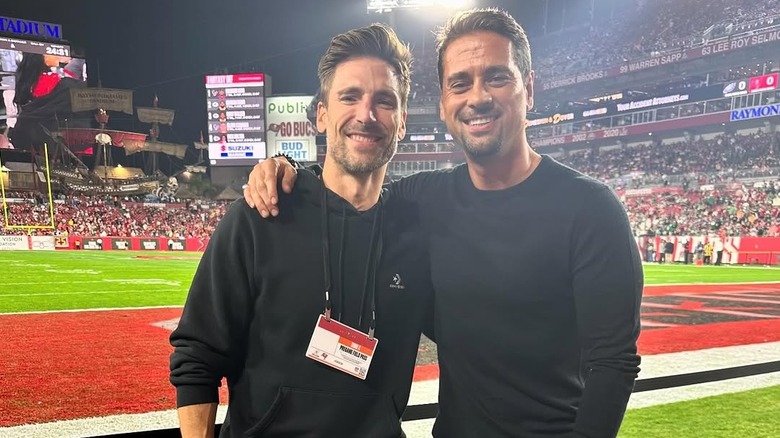 Andrew Walker poses on a football field with a friend