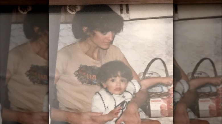 Young Erica Cerra in her mother's arms