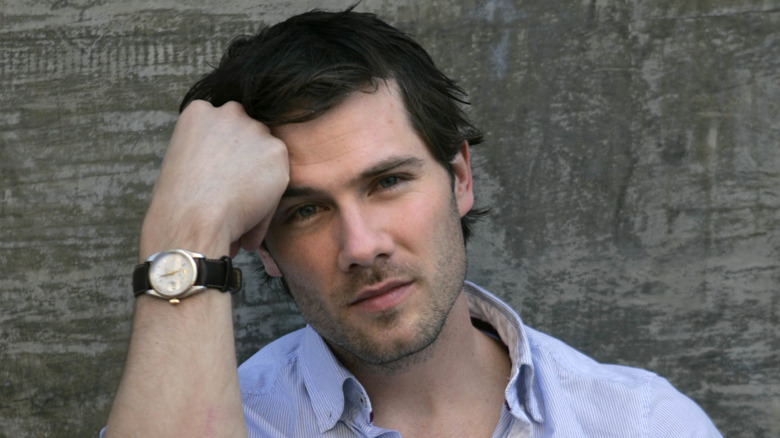 Luke Macfarlane with hand on forehead