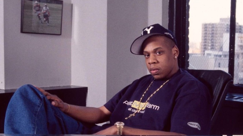 Jay-Z in a baseball cap and purple shirt