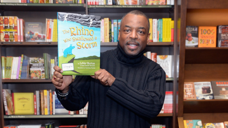 LeVar Burton holding up his children's book