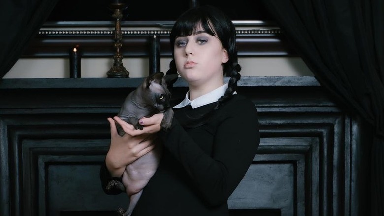 Bailee Ann dressed as Wednesday holding a cat