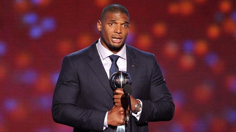 Michael Sam speaking on stage, holding trophy