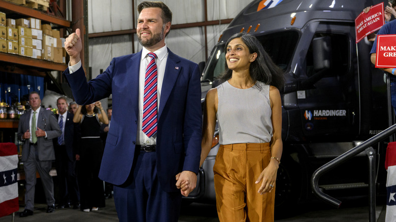 JD and Usha Vance smiling and walking hand in hand.