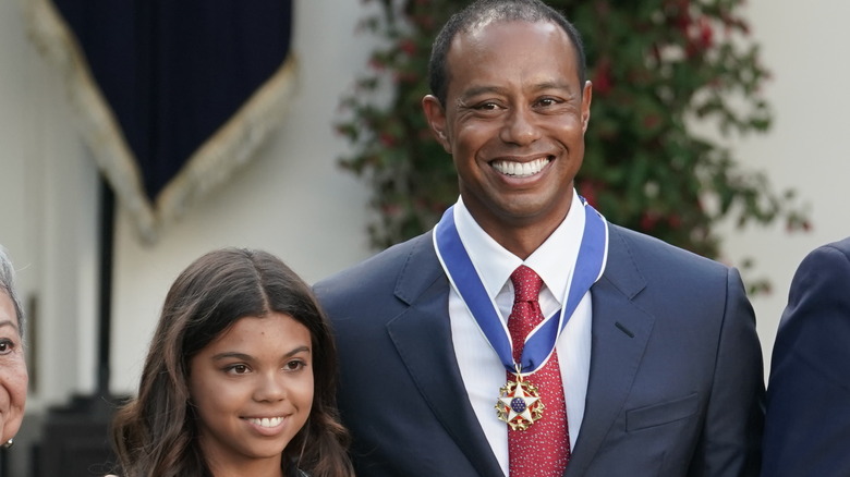 Sam Alexis Woods posing with Tiger Woods