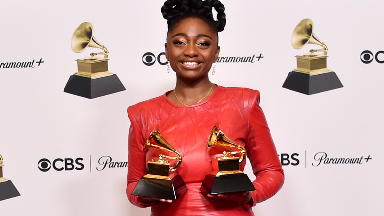 Samara Joy posing with Grammy Awards