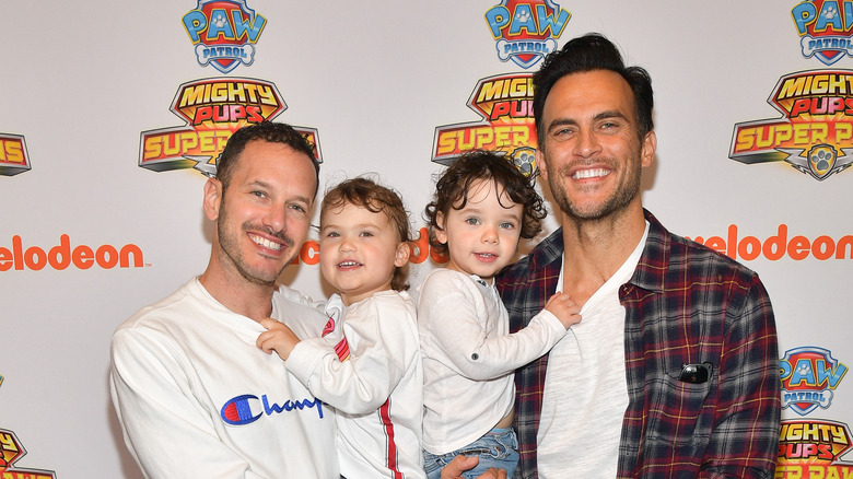 Cheyenne Jackson posing with his husband and kids at an event