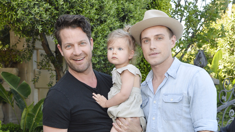 Nate Berkus posing with Jeremiah Brent and their daughter outside
