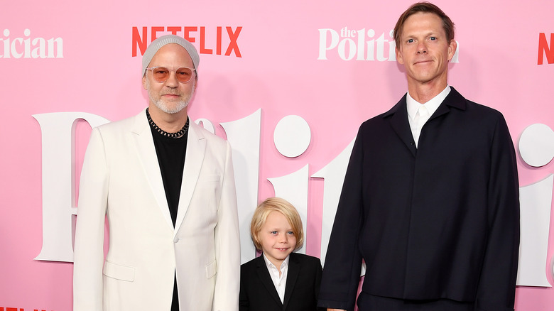 Ryan Murphy and David Miller holding their son's hands on a red carpet