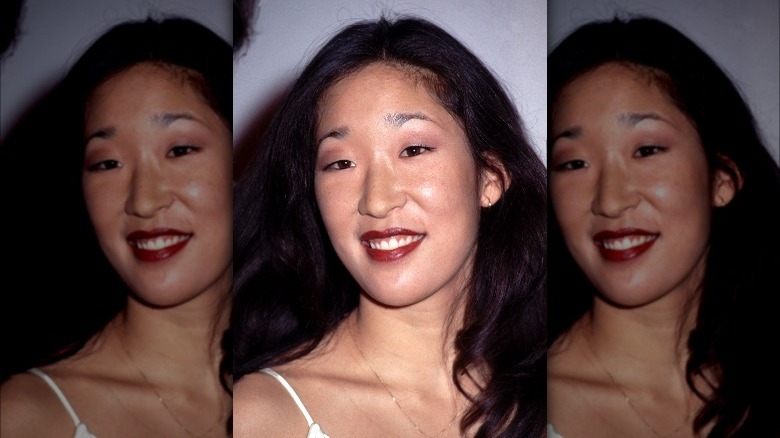 Young Sandra Oh posing in lipstick