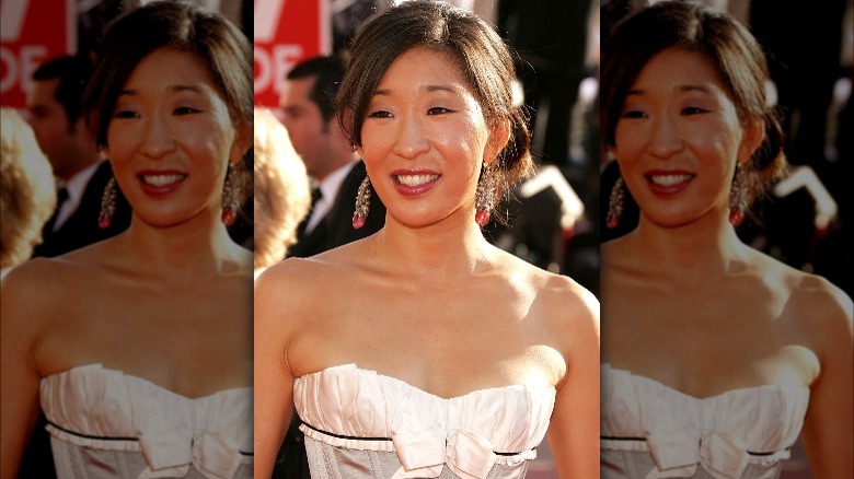 Sandra Oh posing in white bustier