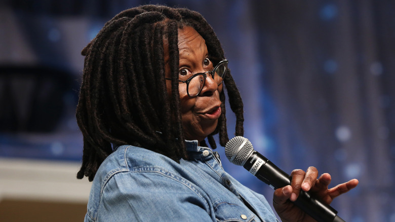 Whoopi Goldberg speaking into a mic