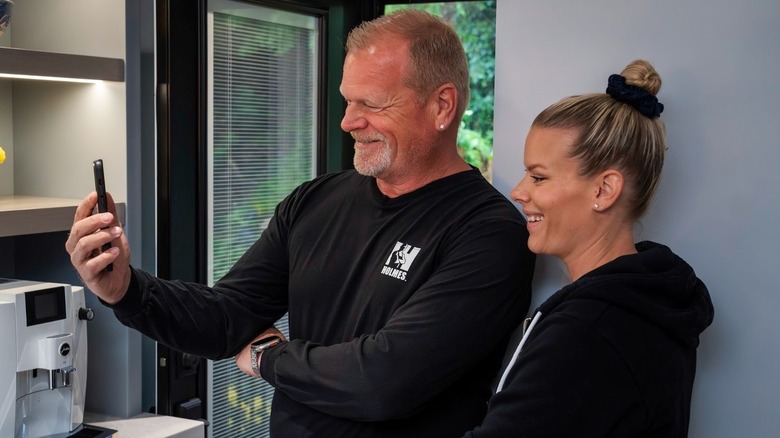 Mike Holmes and Sherry Holmes looking at phone