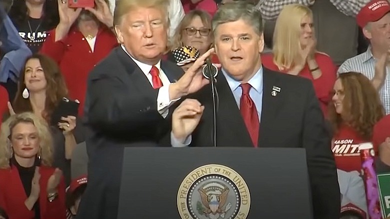 Donald Trump adjusting microphone for Sean Hannity