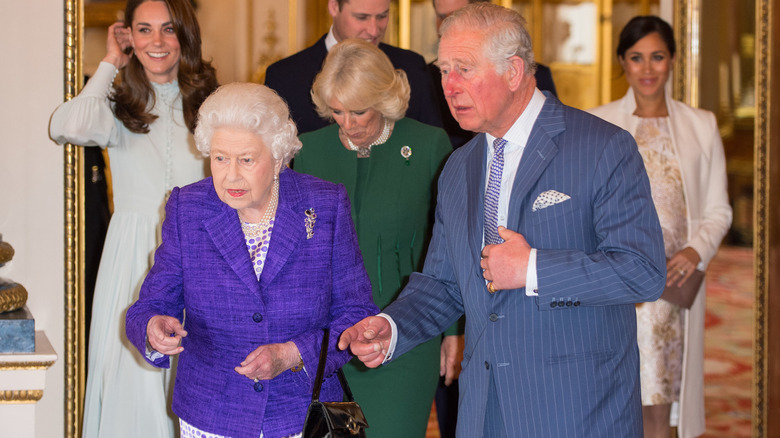 Kate Middleton, Queen Elizabeth, then-Duchess Camilla, Prince Harry, then-Prince Charles, and Meghan Markle walking and talking