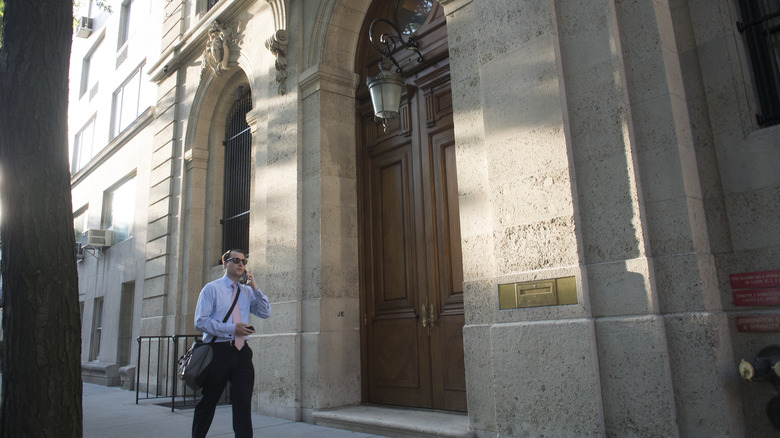 Man walking past Jeffrey Epstein's former townhouse