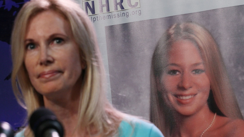 Beth Holloway in front of photo of daughter Natalee