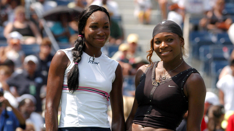 Venus and Serena Williams posing on tennis court