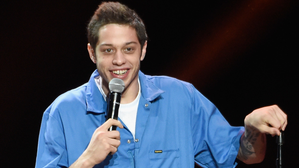 Pete Davidson holding a microphone 