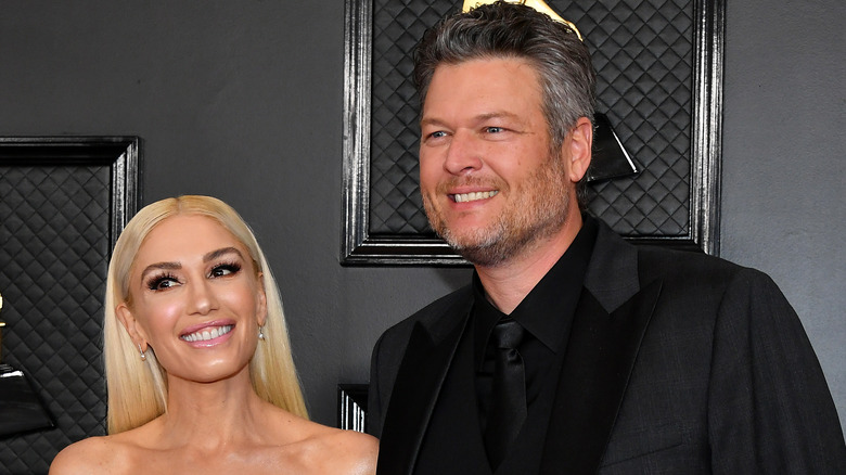 Gwen Stefani and Blake Shelton smiling on the Grammys red carpet