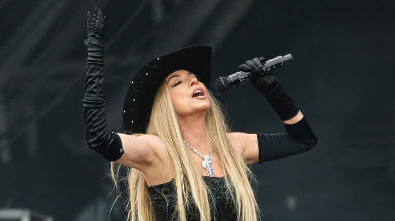 Shania Twain wearing a large pendant while performing at Glastonbury