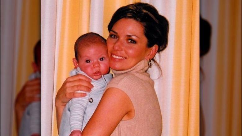 Shania Twain holding her baby, Eja Lange, and smiling