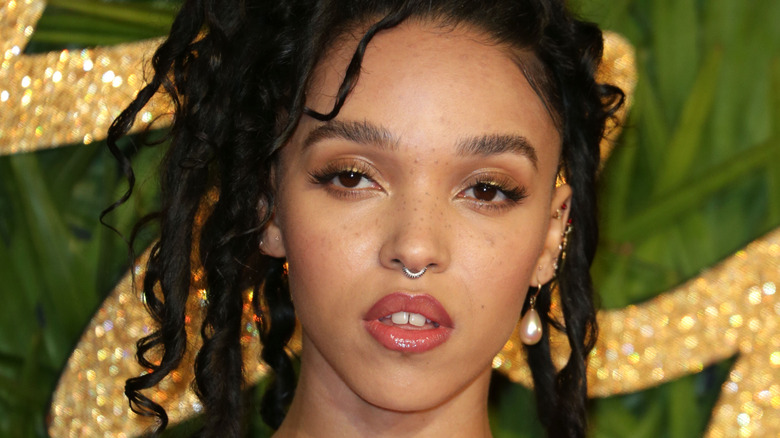 FKA Twigs poses in a nose ring and pearl earring