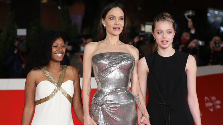 Shiloh Jolie-Pitt, posing with Angelina Jolie and Zahara Jolie-Pitt.