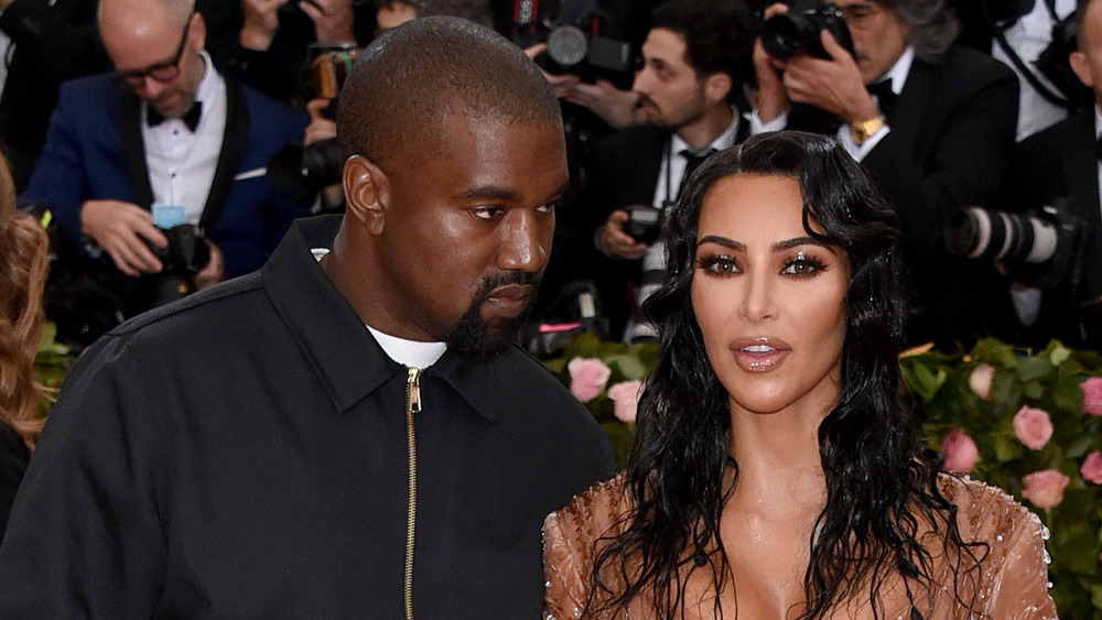 Kanye West leaning in towards wife Kim Kardashian at the 2019 MET Gala 