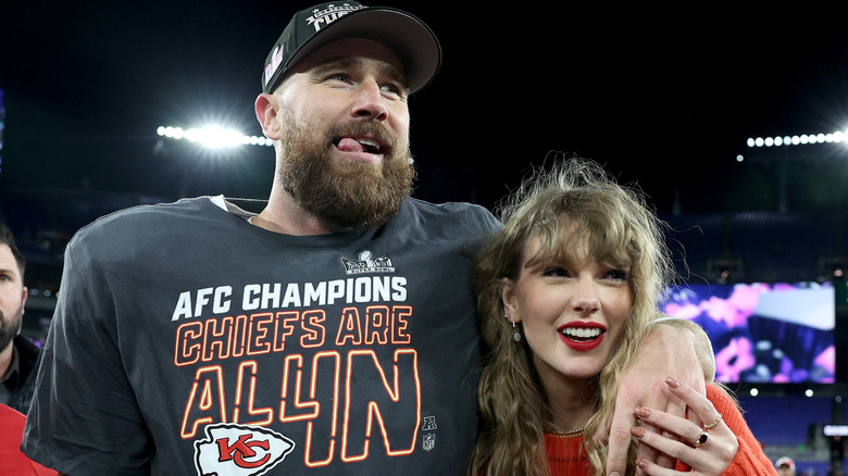 Travis Kelce with his arm around Taylor Swift