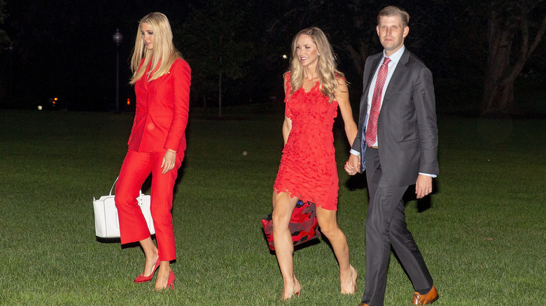 Ivanka, Lara, Eric Trump walking in grass 