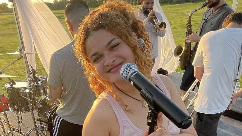 Raquel Trinidad posing behind a microphone