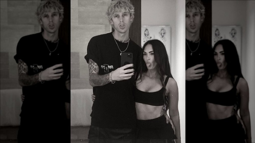 Black-and-white selfie of Machine Gun Kelly and Megan Fox sticking their tongues out
