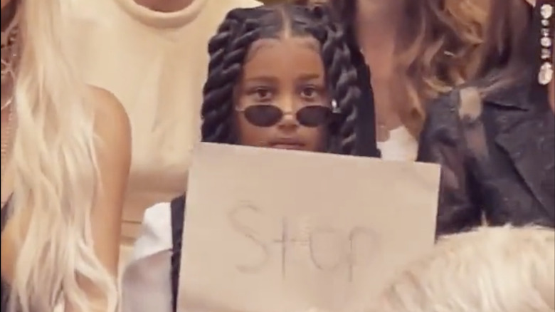 North West holding a "Stop" sign 