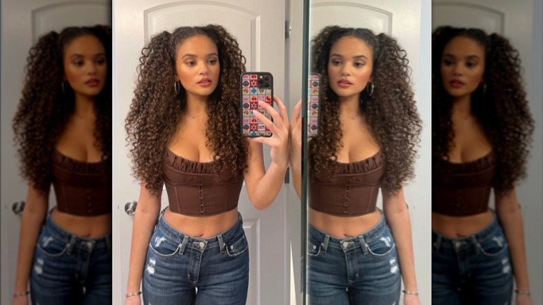 Madison Pettis taking mirror selfie in brown bustier top