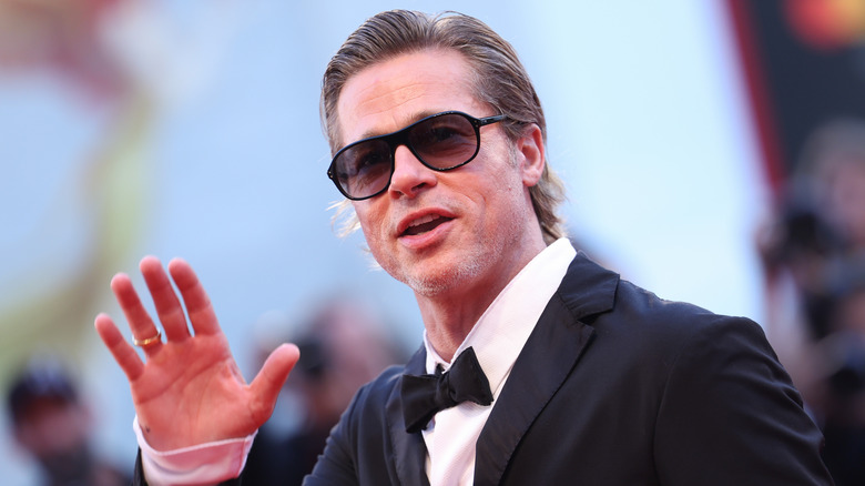 Brad Pitt waving with sunglasses on