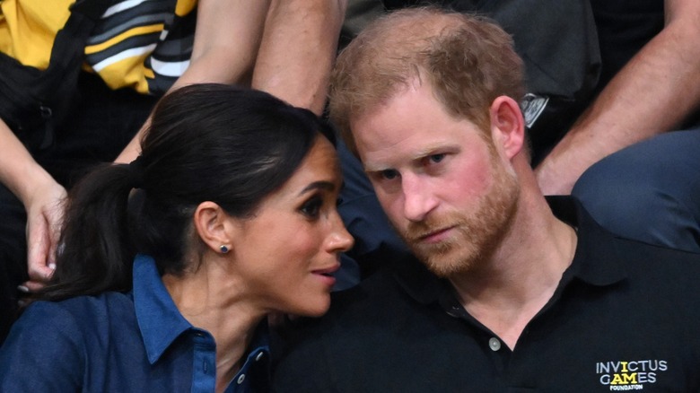 Meghan Markle whispering in Prince Harry's ear