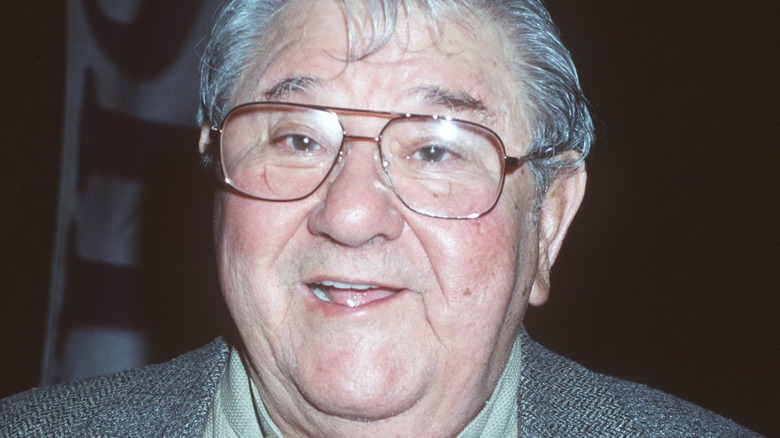 Buddy Hackett smiling on the red carpet