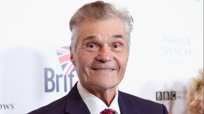 Fred Willard on a red carpet, smiling